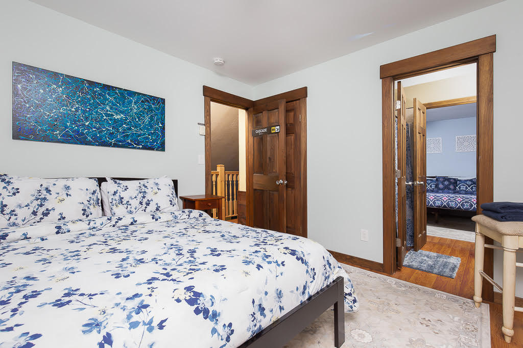 Bedroom with queen bed, floral linens, and blue accent painting