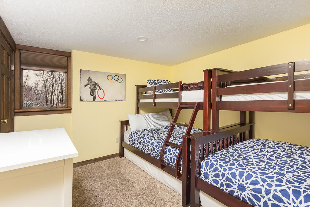 Yellow bunk room with twin-over-full bunks and window view