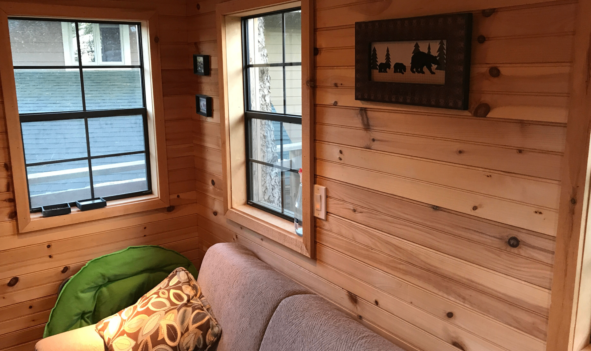 Treehouse interior with futon, green papasan chair, and bear wall art