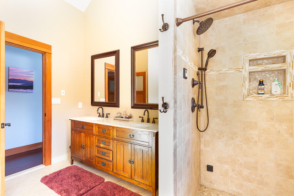 Primary bathroom with double vanity and large tiled walk-in shower