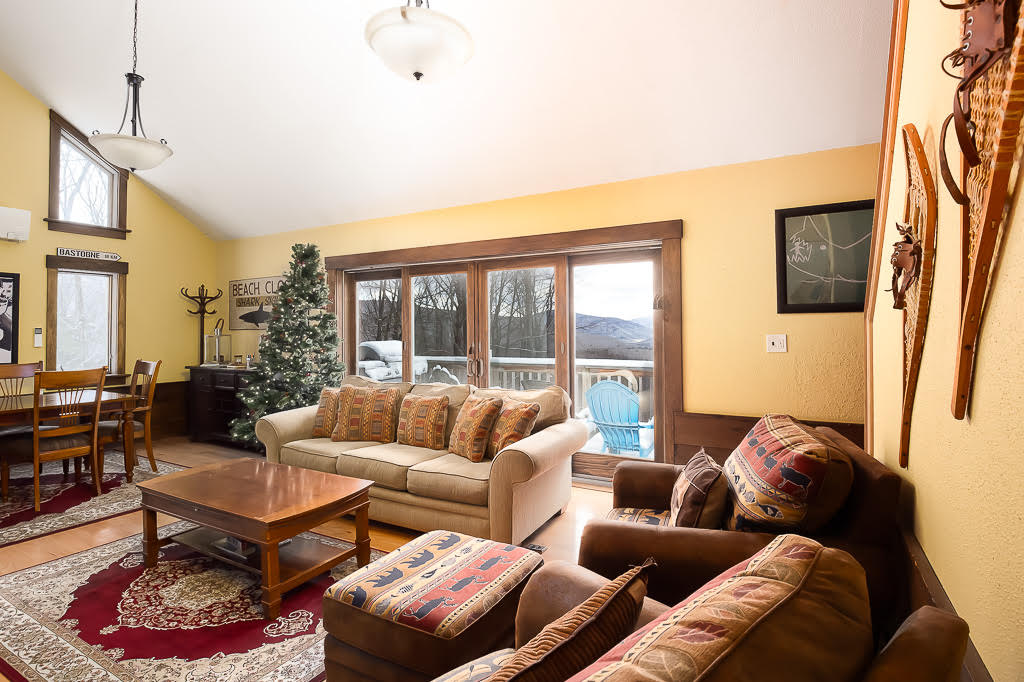 Living room with sliding doors to deck, mountain view, and vintage snowshoes on the wall