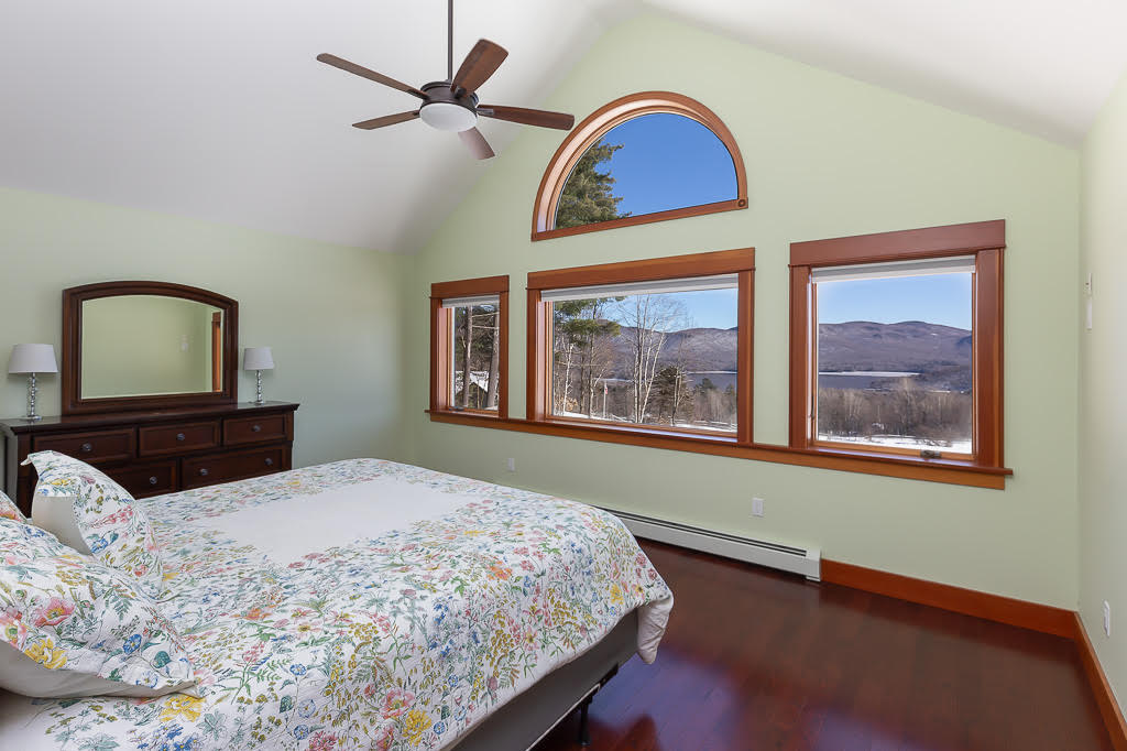 Primary bedroom with king bed, vaulted ceiling, and panoramic reservoir views