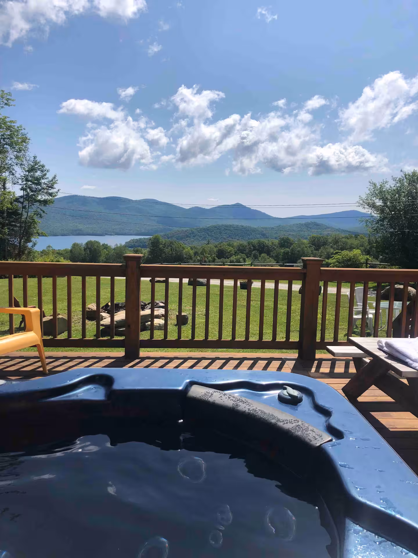 Hot tub on the deck with sweeping summer mountain and reservoir views