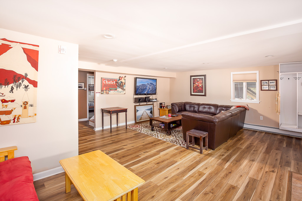 Spacious lower living area with sectional, game table, and entry to bedrooms