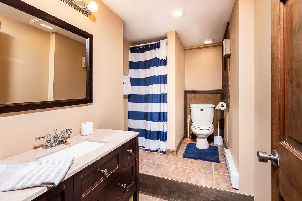 Bathroom with striped blue shower curtain and dark wood vanity