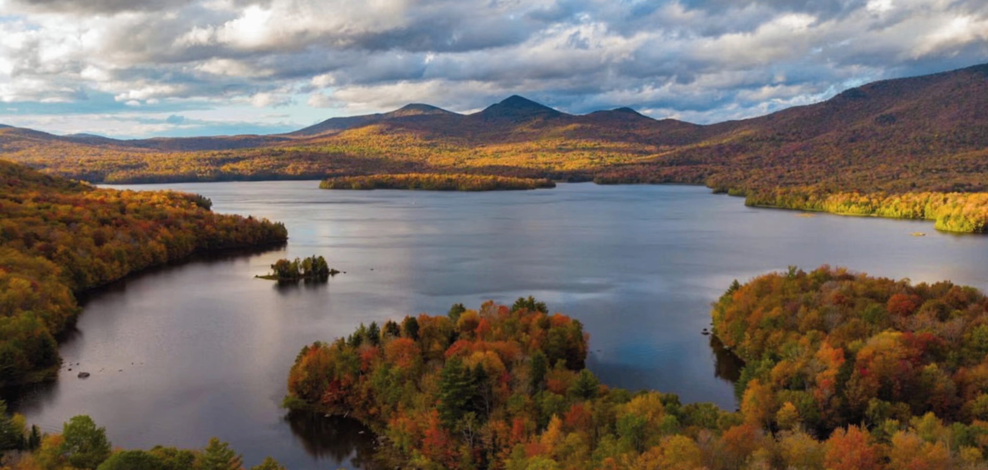 Autumn aerial of Chittenden Reservoir surrounded by peak fall foliage