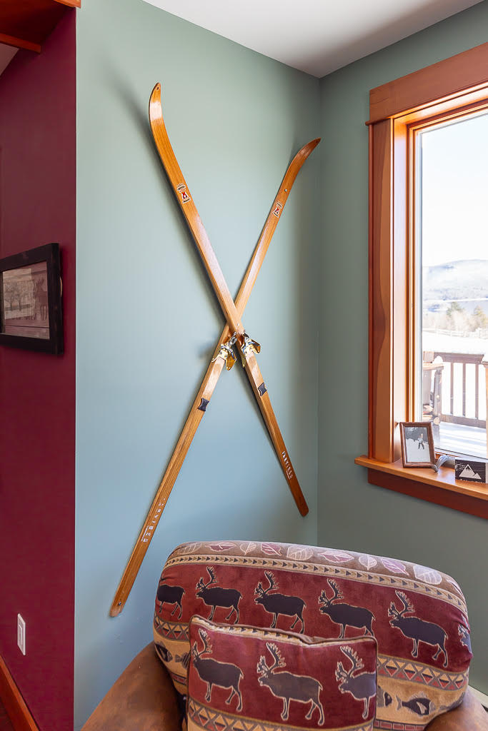 Vintage wooden skis displayed in a sage-walled reading nook