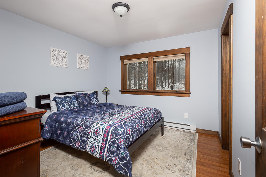 Bedroom with navy paisley bedding and snowy forest view through window