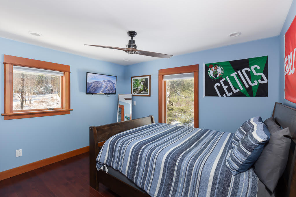 Blue kids' bedroom with Celtics flag, queen bed, and mountain TV view