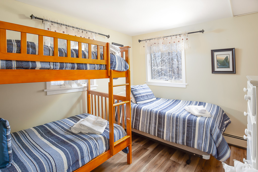 Bunk room with twin-over-twin bunks and an additional twin bed by the window