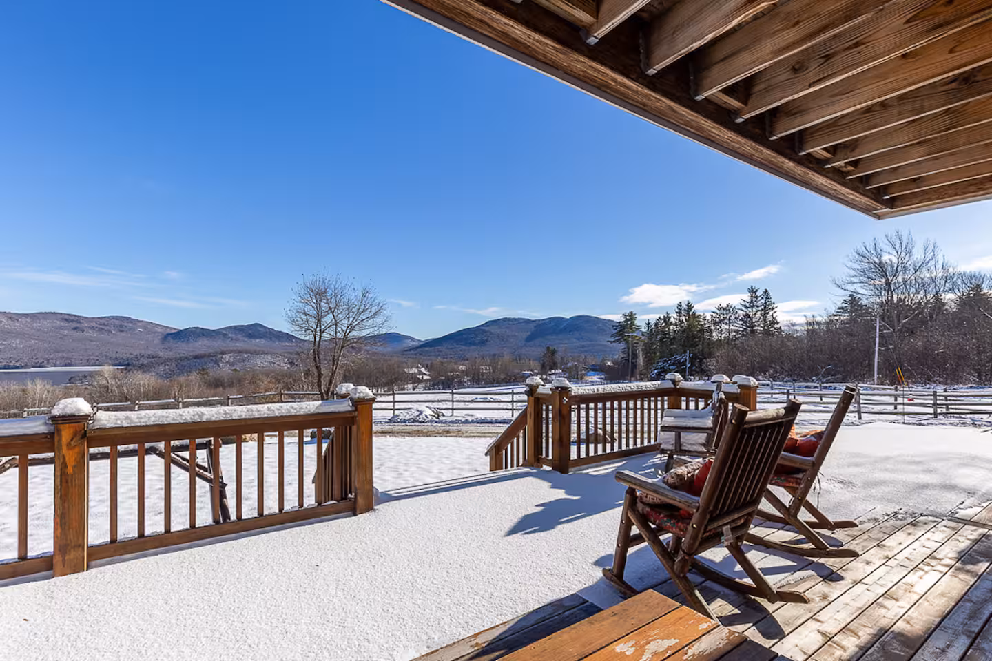 Covered porch dusted with fresh snow framing the Green Mountains