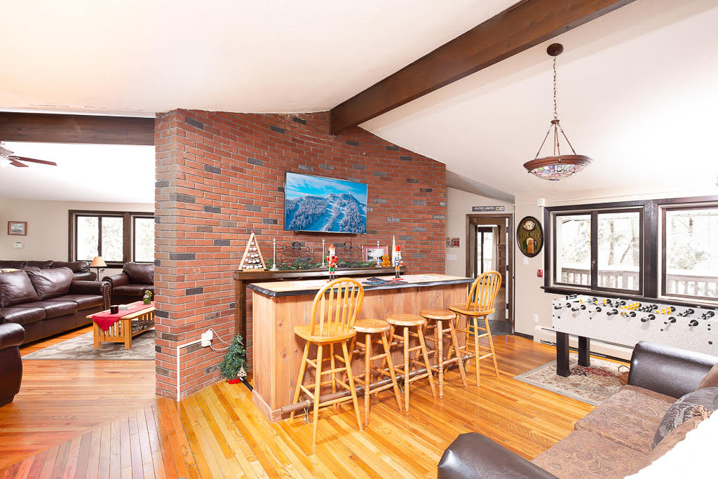 Great room with cedar bar, brick accent wall, and foosball table