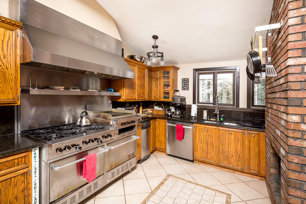Professional chef's kitchen with commercial range and granite counters