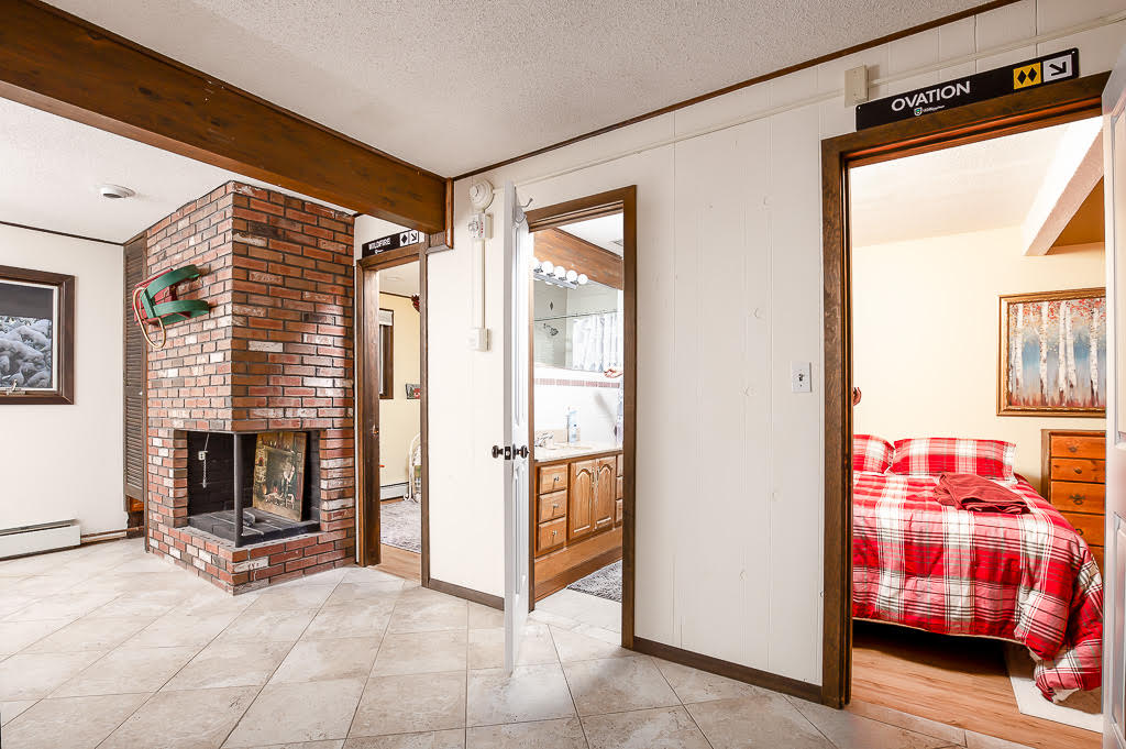 Open hallway with central brick fireplace connecting bedrooms
