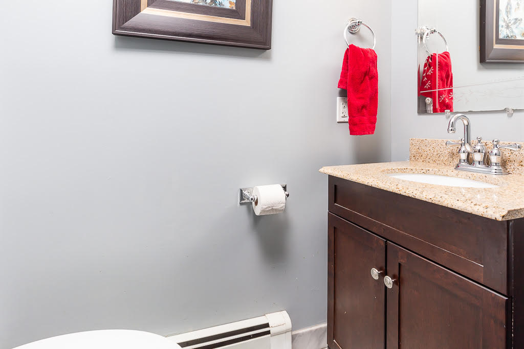 Modern bathroom with granite vanity and dark wood cabinetry